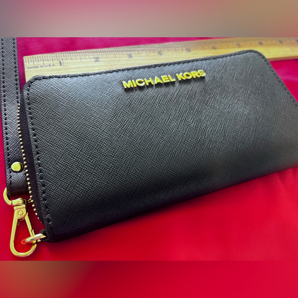 Michael Kors black zipper wallet with gold tracings and zipper.